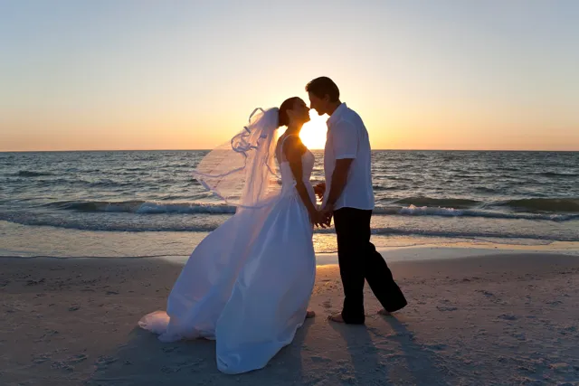 A couple sharing a quiet moment beside the ocean at sunset